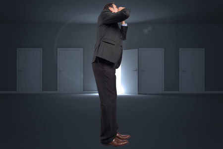 Shouting businessman against door opening revealing lightの写真素材