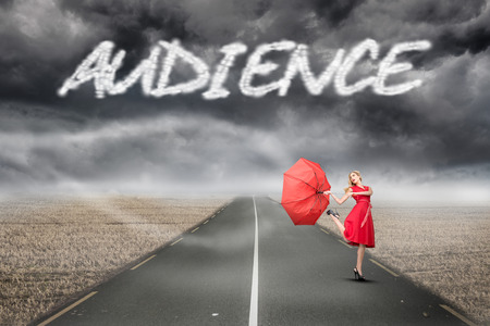 The word audience and beautiful woman posing with a broken umbrella against misty brown landscape with streetの写真素材