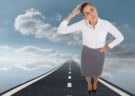 Focused businesswoman against peaceful water and sky and roadの写真素材