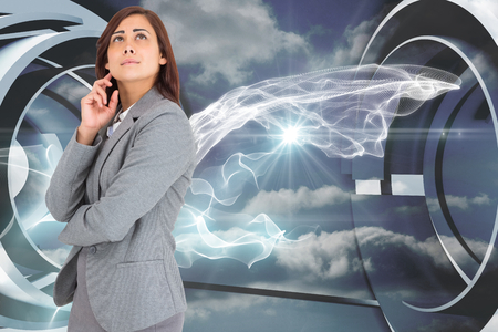 Worried businesswoman against cloud and energy design on a futuristic structureの写真素材