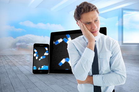 Upset thinking businessman against room with holographic cloudの写真素材