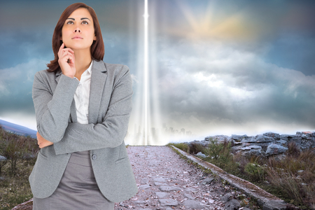 Focused businesswoman against rocky path leading to light beamの写真素材