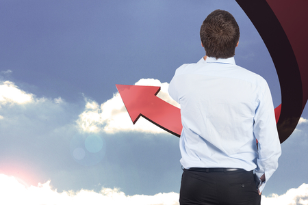 Businessman against red curved arrow pointing up against skyの写真素材