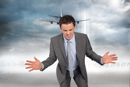 Businessman posing with hands out against city on the horizon with light beamの写真素材