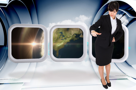 Businesswoman pointing against abstract blue cloud design in futuristic structureの写真素材