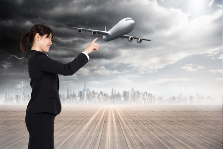 Smiling businesswoman pointing against cityscape on the horizonの写真素材