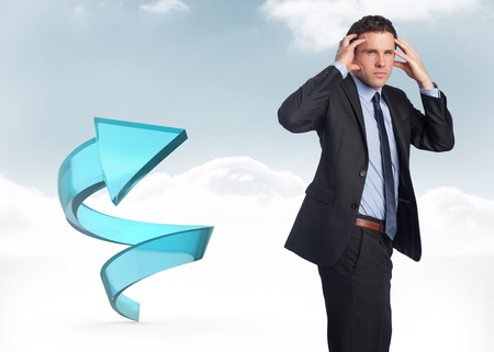 Stressed businessman with hands on head against blue spiral arrow in the skyの写真素材