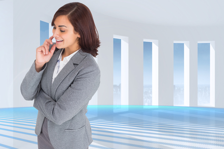 Smiling thoughtful businesswoman against abstract linear design in blueの写真素材