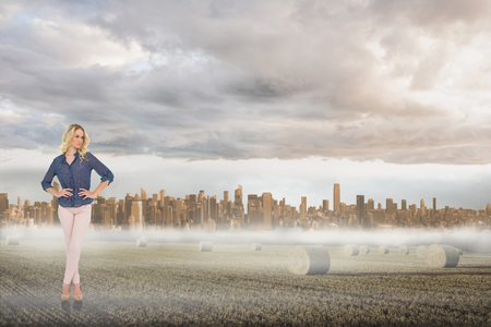 Thoughtful gorgeous blonde wearing classy clothes posing against large city on the horizonの写真素材