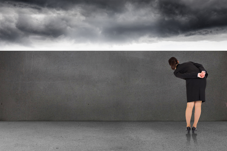 Businesswoman bending against balcony and stormy skyの写真素材