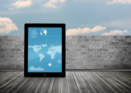 Map on tablet screen against brick lined wall covering half skyの写真素材