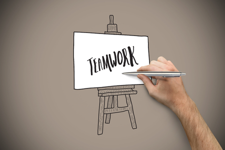 Hand holding a silver pen against grey background with vignetteの写真素材