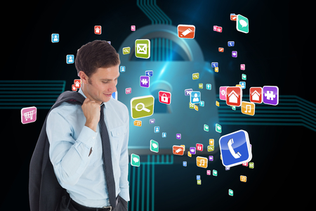 Smiling businessman holding his jacket against shiny lock on black backgroundの写真素材