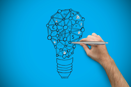 Hand holding a silver pen against blue background with vignetteの写真素材