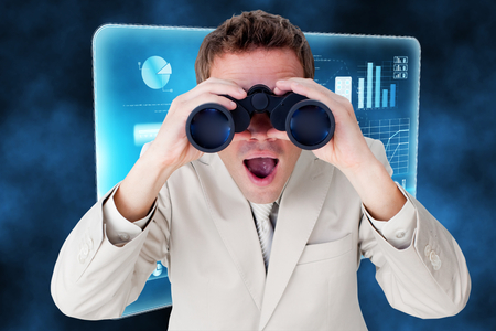Positive businessman using binoculars against futuristic technology interfaceの写真素材