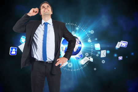 Thinking businessman scratching head against global communication backgroundの写真素材