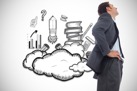Cheerful businessman standing with hands on hips against education illustrationの写真素材
