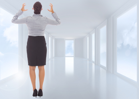 Frustrated businesswoman shouting against bright white hall with windowsの写真素材