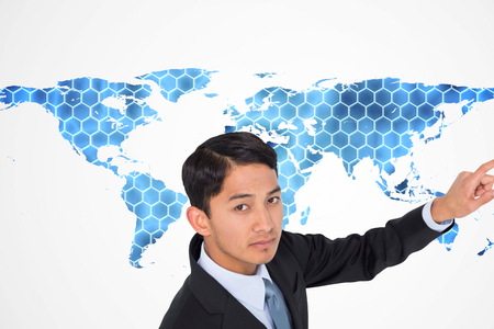 Composite image of unsmiling asian businessman pointingの写真素材