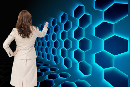 Composite image of businesswoman standing back to camera writing with marker against white backgroundの写真素材