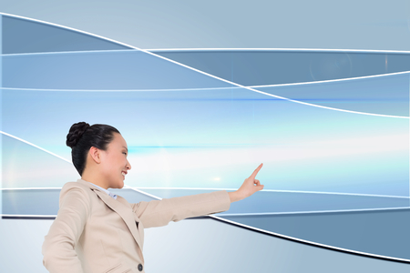 Composite image of smiling asian businesswoman pointingの写真素材