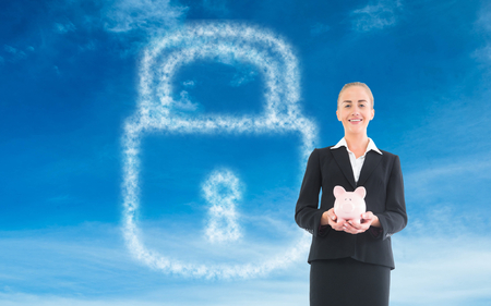 Composite image of blonde businesswoman holding pink piggy bankの写真素材