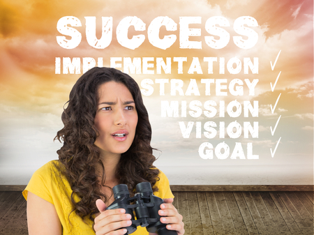 Composite image of serious casual young woman holding binocularsの写真素材