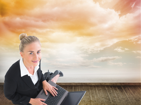 Composite image of blonde businesswoman using laptopの写真素材