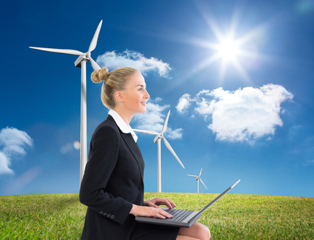 Composite image of blonde businesswoman using laptopの写真素材