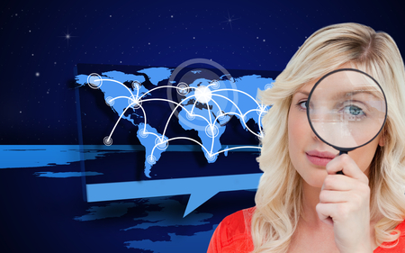 Composite image of fair-haired woman looking through a magnifying glass against a white backgroundの写真素材