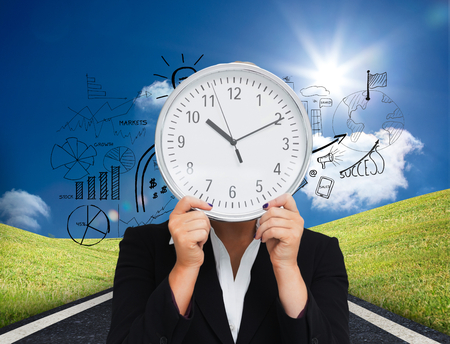 Composite image of businesswoman in suit holding a clock against white backgroundの写真素材
