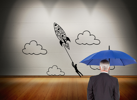 Composite image of mature businessman holding umbrellaの写真素材