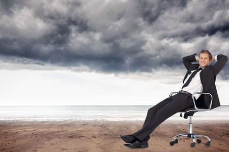 Composite image of young businesssman in office sitting on chairの写真素材