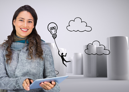 Composite image of smiling model wearing winter clothes holding her tabletの写真素材