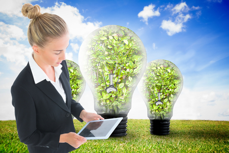 Composite image of blonde businesswoman holding new tabletの写真素材