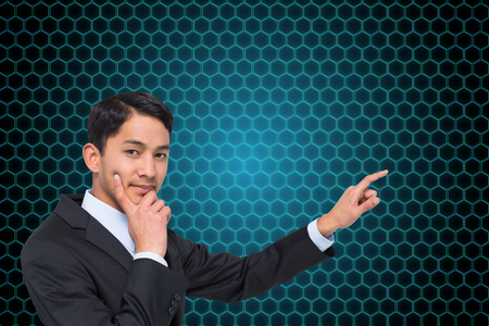 Composite image of thoughtful asian businessman pointingの写真素材
