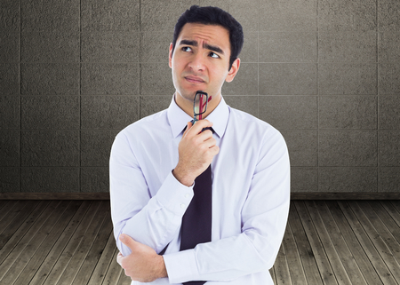 Composite image of thinking businessman holding glassesの写真素材