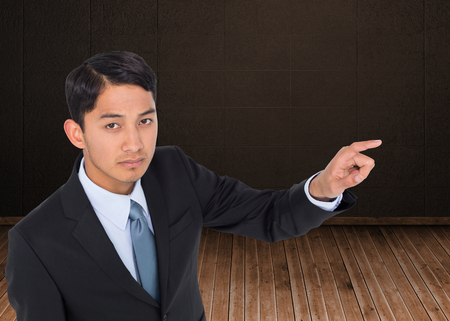 Composite image of unsmiling asian businessman pointingの写真素材