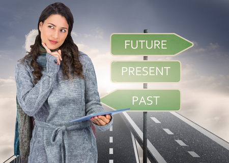 Composite image of pensive model wearing winter clothes holding her tabletの写真素材