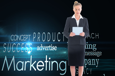 Composite image of blonde businesswoman holding new tabletの写真素材