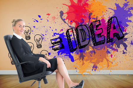 Composite image of blonde businesswoman sitting on swivel chair in black suitの写真素材