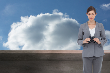 Composite image of young businesswoman with binocularsの写真素材