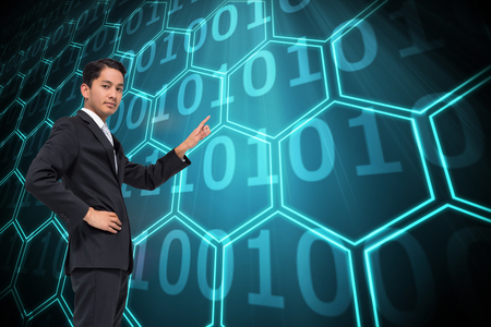 Composite image of unsmiling asian businessman pointingの写真素材