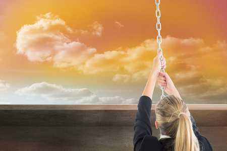 Composite image of blonde businesswoman pulling a chainの写真素材