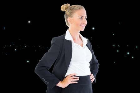 Composite image of blonde businesswoman standing with hands on hipsの写真素材