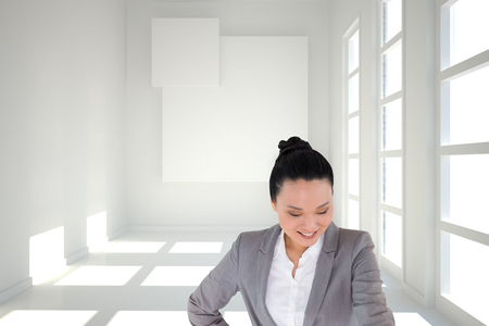 Composite image of smiling asian businesswoman pointingの写真素材