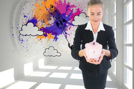 Composite image of blonde businesswoman holding pink piggy bankの写真素材