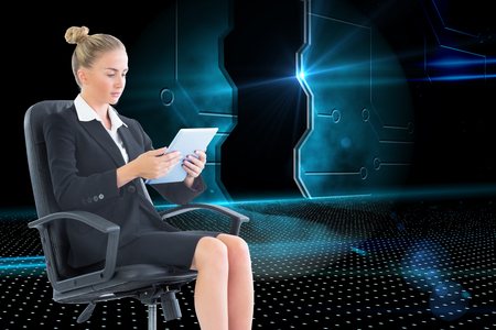 Composite image of blonde businesswoman sitting on swivel chair with tabletの写真素材
