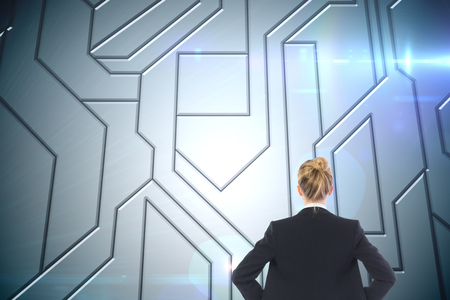 Composite image of blonde businesswoman standing with hands on hipsの写真素材