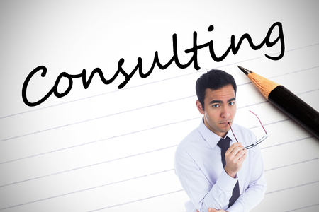 Composite image of unsmiling businessman holding glassesの写真素材